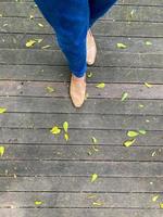 vrouwen poten in een gemakkelijk bruin schoenen. top visie van vrouw been vervelend schoenen en mager blauw jeans. gemakkelijk en straat mode. foto