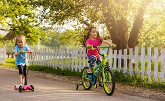 weinig meisje rijden fiets in stad park. foto