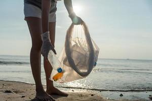 opslaan water. vrijwilliger plukken omhoog uitschot vuilnis Bij de strand en plastic flessen zijn moeilijk ontleden voorkomen kwaad aquatisch leven. aarde, omgeving, vergroening planeet, verminderen globaal opwarming, opslaan wereld foto