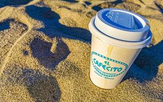 puerto escondido oaxaca Mexico 2023 koffie naar Gaan mok Aan de strand zand zee golven. foto