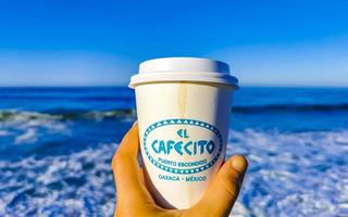 puerto escondido oaxaca Mexico 2023 koffie naar Gaan mok Aan de strand zand zee golven. foto