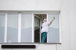 een verpleegster in een ziekenhuis of kliniek wast ramen. een schoonmaakster in een medisch faciliteit. foto