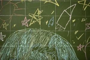 tekeningen van kinderen met krijt Aan een school- groen bord. foto