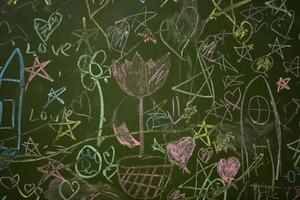 tekeningen van kinderen met krijt Aan een school- groen bord. foto