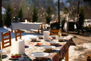 een tafel reeks voor gasten onder de Open lucht in winter foto