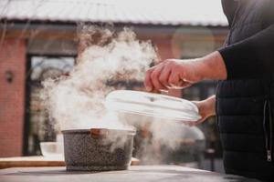 de koken kookt buitenshuis in winter, mooi stoom- van een vers gekookt schotel foto