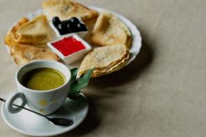 pannenkoek met rood kaviaar en olijven voor ontbijt, munt koffie foto