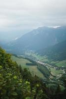 majestueus bergen in de Alpen gedekt met bomen en wolken foto