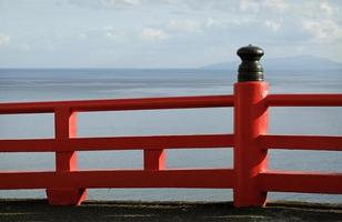 rood hek in de buurt de kust met de zee in de achtergrond in enoshima, Japan foto