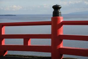 rood hek in de buurt de kust met de zee in de achtergrond in enoshima, Japan foto