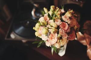 mooi bruidsboeket. stijlvolle bruidsboeket bruid van roze rozen, witte anjer en groene bloemen. zijaanzicht. bruiloft decor. foto