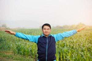 portret van Aziatisch Mens trainingen buitenshuis, armen uitgestrekt. warm omhoog voordat of koel naar beneden na oefening. concept, Gezondheid zorg. sport , creatief werkzaamheid. geven tijd voor jezelf. foto