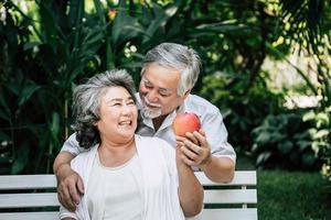 bejaarde echtpaar spelen en eten wat fruit foto