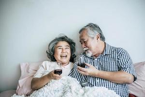 bejaarde echtpaar genieten van hun verjaardag in de slaapkamer foto