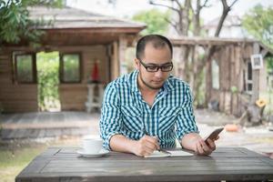 jonge zakenman met behulp van smartphone tijdens het werken in de tuin foto