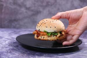 hand met een rundvlees hamburger op een tafel close-up