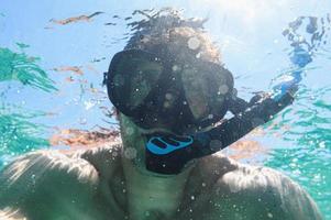 Mens snorkelen met duiken masker in de zee foto