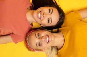 twee vrienden glimlach samen. geel achtergrond. vriendschap concept foto