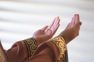 handen van een moslim of islamitische vrouw gebaren tijdens het bidden thuis foto