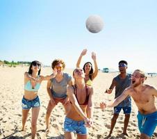 groep van vrienden spelen Bij strand volley Bij de strand foto