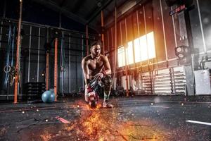 atletisch jongen werken uit Bij de Sportschool met een vurig kettlebell foto