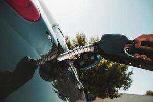 brandstof pomp vullen een tank van een auto in een station foto