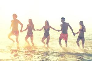 groep van vrienden rennen in de zee. concept van zomertijd foto