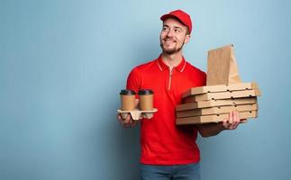 koerier is gelukkig naar leveren heet koffie en pizza. cyaan achtergrond foto