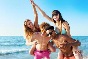 vrolijk jong vrienden genieten van zomertijd Aan de strand foto