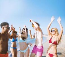 groep van vrienden dansen Aan de strand foto