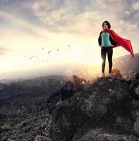 geslaagd zakenvrouw handelingen Leuk vinden een super held Aan een berg. concept van bepaling en succes foto