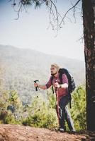 man reiziger met rugzak kijken naar de kaart tijdens alpinisme foto