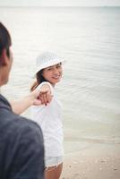 vriendin neemt haar vriend mee naar het strand foto