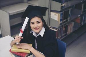gelukkige afgestudeerde student met een diploma in de hand foto