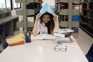 portret van student die haar hoofd bedekt met een boek tijdens het lezen foto