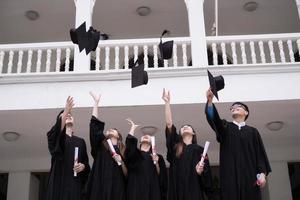 groep succesvolle studenten afstuderen hoeden in de lucht gooien en vieren