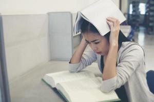 portret van een student die haar hoofd bedekt met een boek