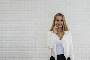 jonge zakenvrouw met behulp van smartphone tijdens het werken op kantoor foto