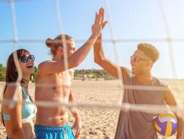 groep van vrienden spelen Bij strand volley Bij de strand foto