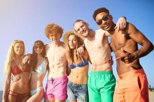 groep van vrienden hebben pret Aan de strand foto