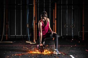atletisch meisje werken uit Bij de Sportschool met een vurig kettlebell foto