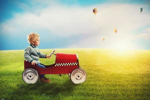 kind met auto Toneelstukken in een groen veld- foto