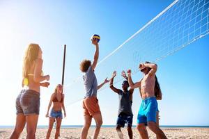 groep van vrienden spelen Bij strand volley Bij de strand foto