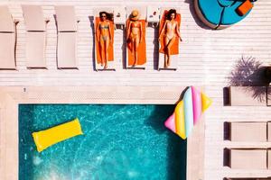 vrienden in zwempak wie bruinen in de zonnebank in een zwemmen zwembad foto