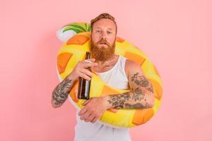 echt Mens is klaar naar zwemmen met een donut redder in nood met bier en sigaret in hand- foto