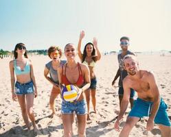 groep van vrienden spelen Bij strand volley Bij de strand foto