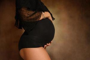 zwanger vrouw ervan uitgaand een kind liefkozingen haar buik foto