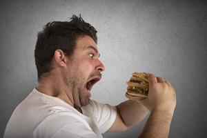 onverzadigbaar en hongerig Mens aan het eten een belegd broodje foto