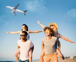 gelukkig glimlachen paren spelen Bij de strand met vliegtuig in de lucht foto