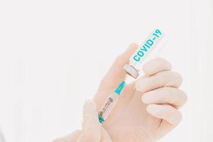 dokter met injectiespuit is klaar naar beheren de vaccin tegen covid-19 foto